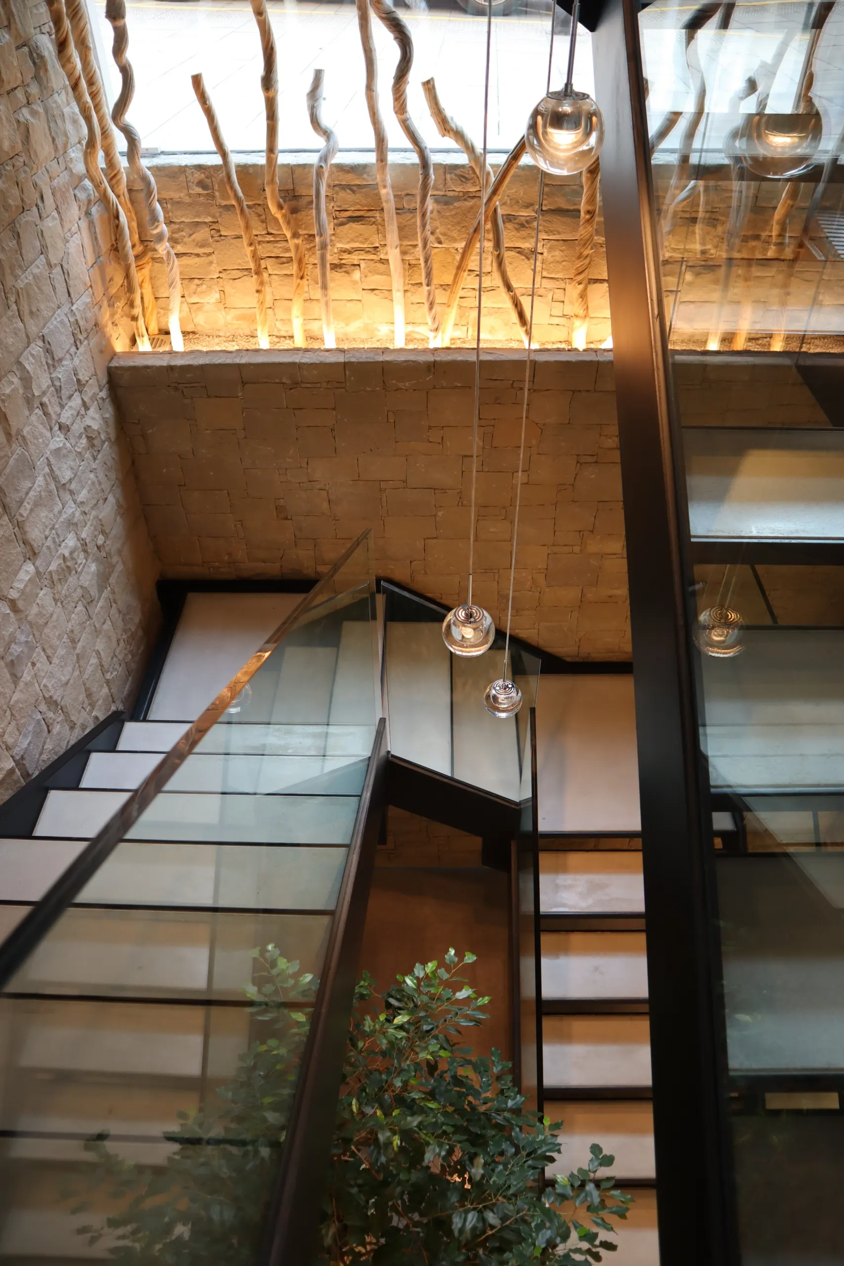 Escalera interior de piedra y cristal en un edificio de Edificaciones Moreno